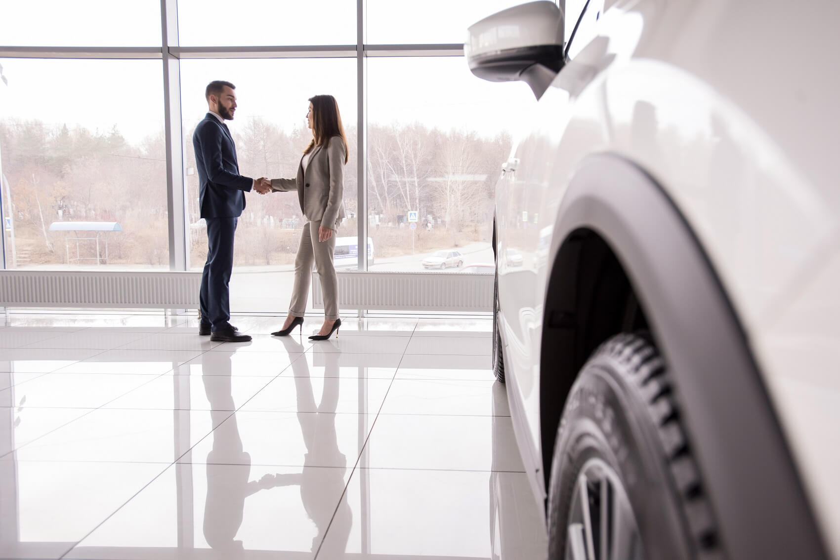 A man and woman shaking hands after completing a trade-in transaction
